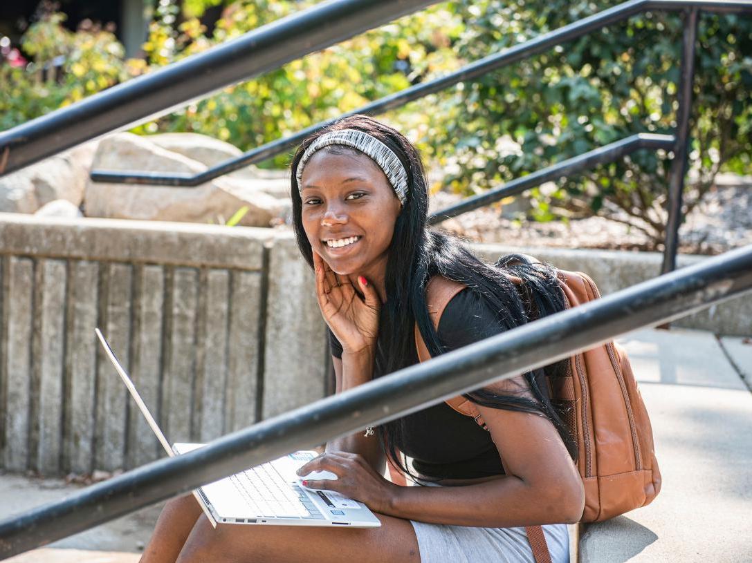 Female student sitting and studying outdoors.